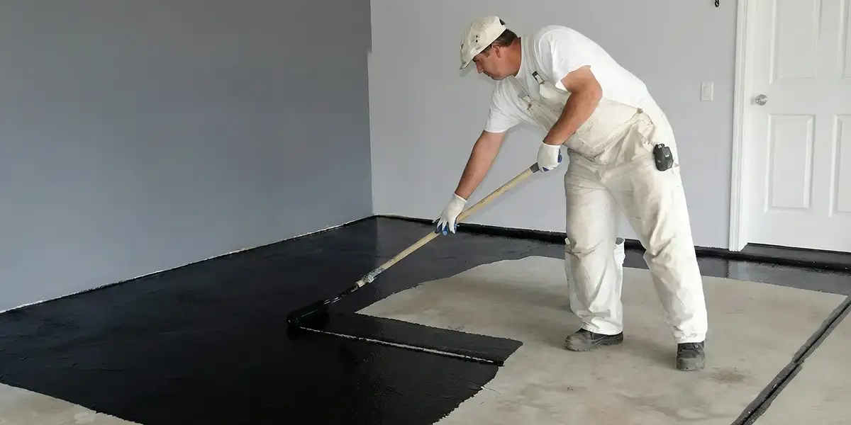 basement waterproofing professional applying waterproof coating to protect a basement floor in San Diego, CA