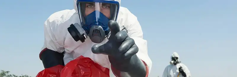 sewage clean up technician wearing protective gear handling biohazard materials in San Diego, CA